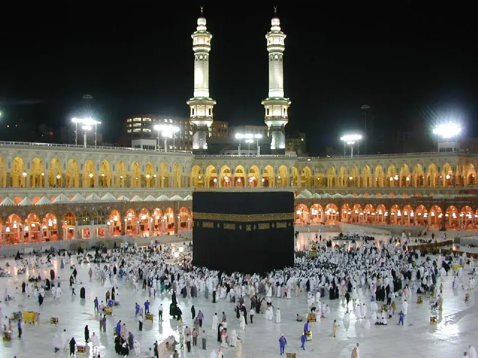 The Kaaba draped in its black and gold kiswa at the center of the Grand Mosque in Mecca, surrounded by pilgrims