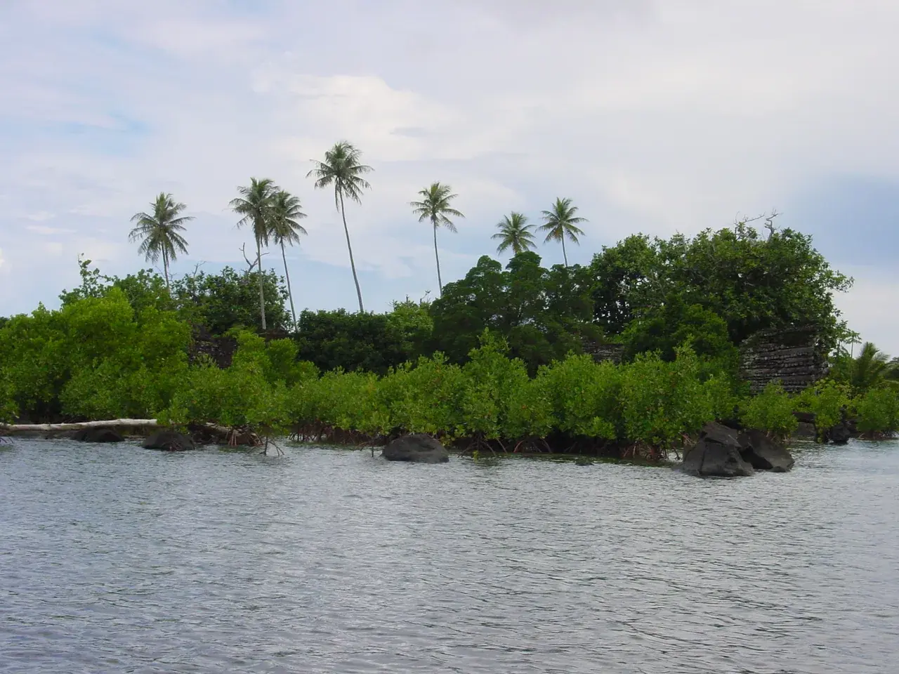 Walls of stacked columnar basalt rising from a shallow tidal channel at the Nan Madol ruins off Pohnpei