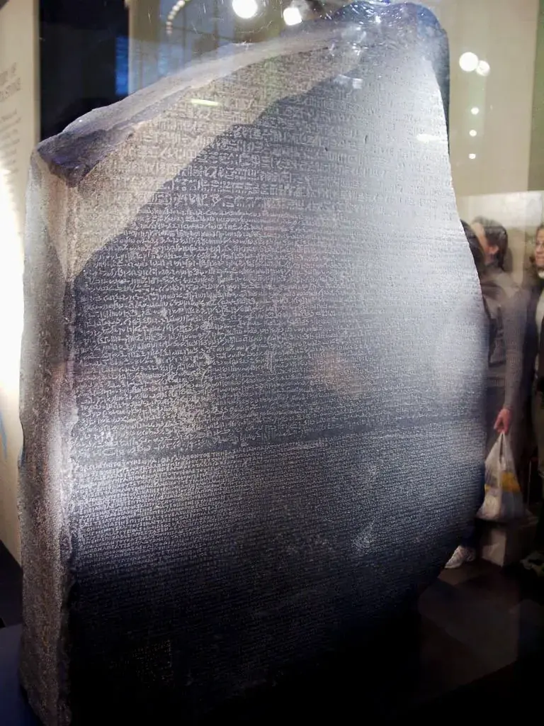The Rosetta Stone, showing the same decree carved in hieroglyphic, Demotic, and Greek script