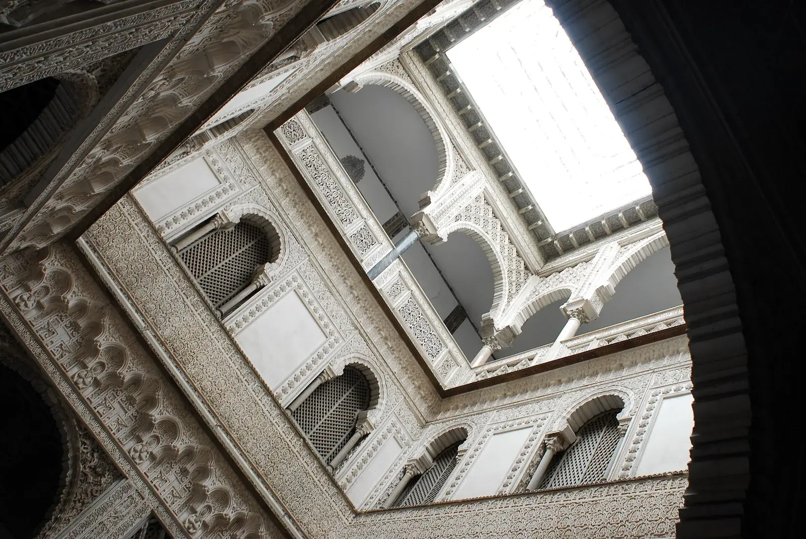 The horseshoe arches and intricate tilework of a Moorish palace courtyard in southern Spain